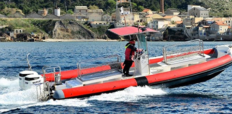 Bateau rouge sur l'eau, avec deux moteurs Suzuki